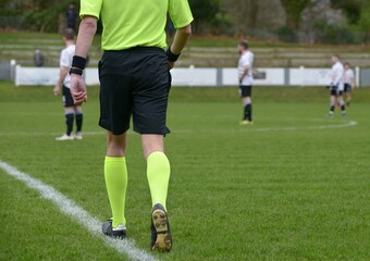 Fototapeta premium l'arbitre se dirigeant vers le centre du terrain au football