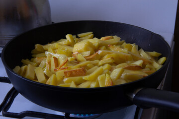 Crispy golden potatoes in a frying pan in the kitchen 
