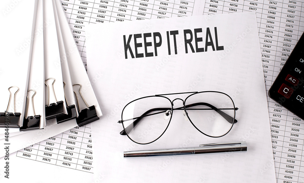 Poster keep it real text on paper on chart background near calculator