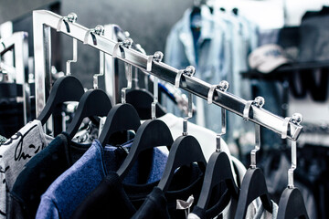 Different men's clothes on hangers in a store close-up