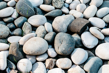 Multicolored smooth natural stones on the grass