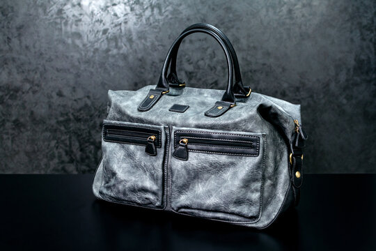 Gray leather bag on a dark background