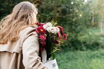 Girl with a bouquet from behind in the park