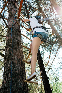 Woman climbing a rope ladder outdoors in team building
