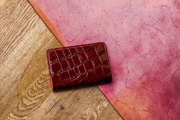 Red passport cover made of genuine leather on a wooden background