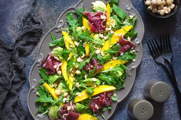 Salad with mango, avocado, arugula and jamon