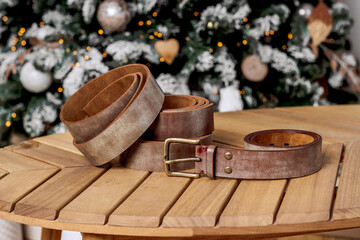 Brown genuine leather straps on a wooden table