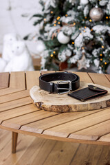 Black belt and wallet made of genuine leather on a wooden table