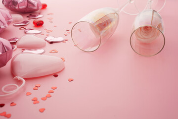 Fototapeta premium Valentines day pink background with two champagne glasses, hearts and roses.