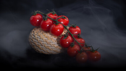 juicy ripe red cherry tomatoes. bright fresh tomatoes on a black background. smoking