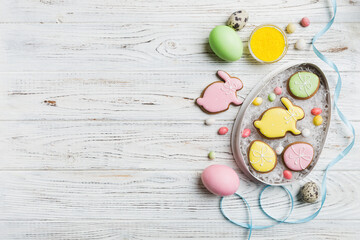 Colorful easter cookies in basket with Multi colors Easter eggs on colored background . Pastel color Easter eggs. holiday concept with copy space