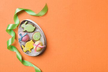 Colorful easter cookies in basket with Multi colors Easter eggs on colored background . Pastel color Easter eggs. holiday concept with copy space