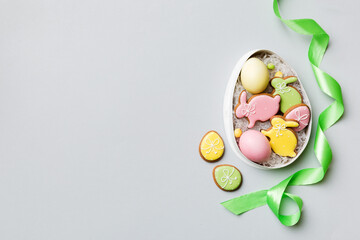 Fototapeta na wymiar Colorful easter cookies in basket with Multi colors Easter eggs on colored background . Pastel color Easter eggs. holiday concept with copy space