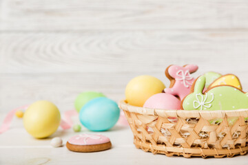 Colorful easter cookies in basket with Multi colors Easter eggs on colored background . Pastel...