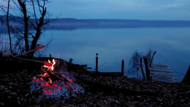 Sausages fried over a wood fire near lake in nature