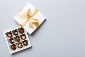 White box with chocolates candies and golden tape. top view with copy space