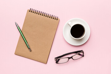 Modern office desk table with notebook and other supplies with cup of coffee. Blank notebook page for you design. Top view, flat lay