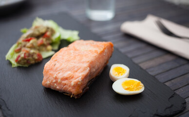 baked salmon fillet with homemade guacamole and quail eggs halves