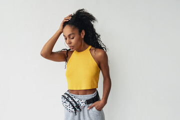 attractive black african american woman posing in stylish hipster outfit on white background