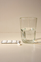 Pasillas des inflamatorias analgésico y antifebril con un vaso de agua para mejorar el estilo de vida y la salud personal.