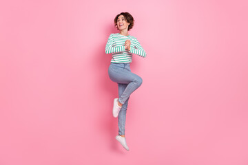 Full length body size view of attractive cheerful amazed girl jumping having fun reaction isolated over pink pastel color background