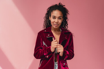 attractive black african american woman in stylish outfit on pink background
