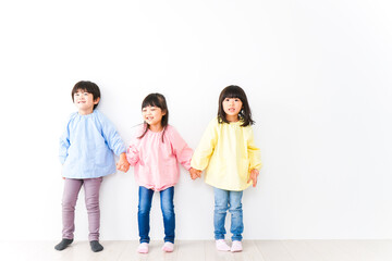 Obraz premium 壁に並ぶ3人の幼稚園児