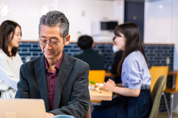 カフェで仕事をする中年男性