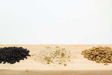 Black rice, rice, oat on a wooden cutting board.