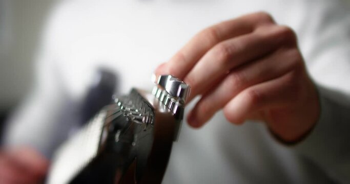 Close-up of the guitarist turns the knobs on the neck of an electric guitar.Black background. High-quality 4K video. Shot with RED camera. Slow motion.
