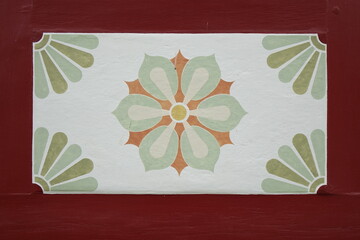 Close up of colourfully painted antique flower ornament on the wall of a German red framework house (horizontal), Bad Salzdetfurth, Lower Saxony, Germany