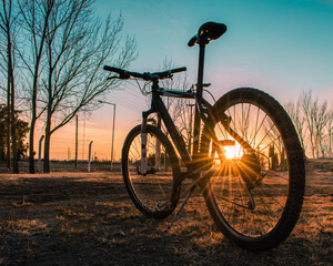 Obraz premium bicicleta todo terreno en el campo en un camino de tierra en un hermoso atardecer o amanecer.