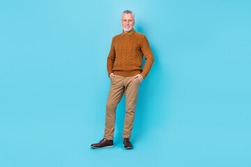 Photo of positive cheerful man put hands pockets isolated over sky light color background