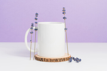 Blank mockup mug on wooden coaster with lavender, trendy purple colors, cup for logo or design