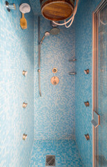 Close-up of shower. Modern interior of bathroom. Small blue tile.
