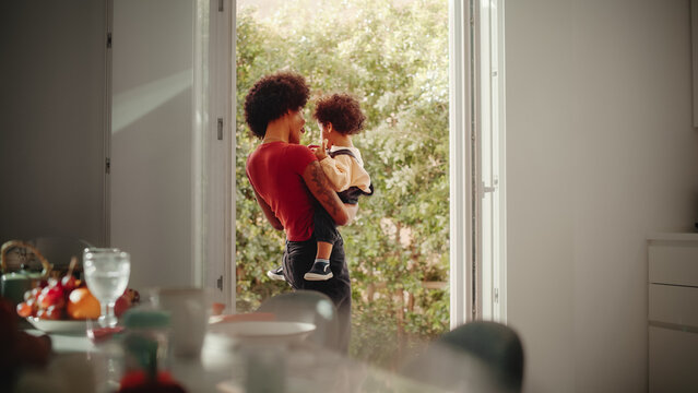 Happy Mother Holding Adorable Baby Boy, Playing, Having Fun At Modern Home Living Room. Latina Female Holding Toddler Child On Her Arms. Concept Of Childhood, New Life, Parenthood.