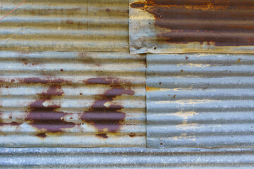 Rusted old galvanized roofing sheets used to make walls of houses of poor rural people
