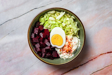 A healthy meal, baked beetroot, cabbage, boiled egg, greek yogurt and chili flakes, overhead view, close-up