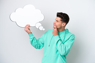 Young handsome caucasian man isolated on white bakcground holding a thinking speech bubble
