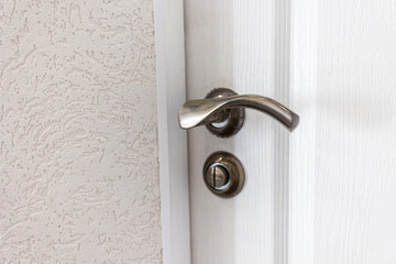 door handle on a wooden light door door close-up