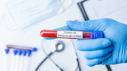 Omicron mutation coronavirus variant. Medical laboratory doctor holding test tube in hospital...
