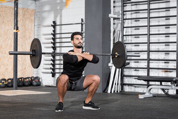 Fototapeta na wymiar Arabian sportsman lifting barbell in gym.