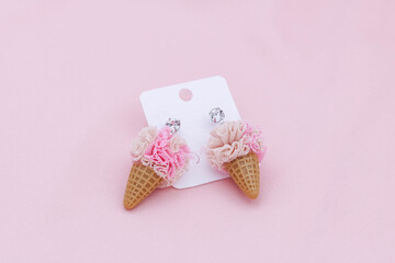 Ice-cream design earrings on pink background.