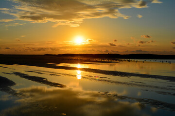 Sunset at low tide over the sea with birds