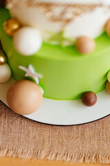 part of two-tiered white-green cake with balls,stars and teddy bear for birthday