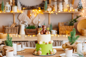 two-tiered white-green cake with balls, stars and teddy bear for birthday.