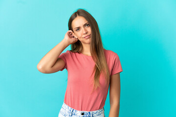 Young woman over isolated blue background having doubts