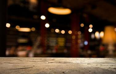 Empty dark wooden table in front of abstract blurred bokeh background of restaurant . can be used for display or montage your products.Mock up for space