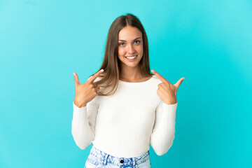 Young woman over isolated blue background giving a thumbs up gesture