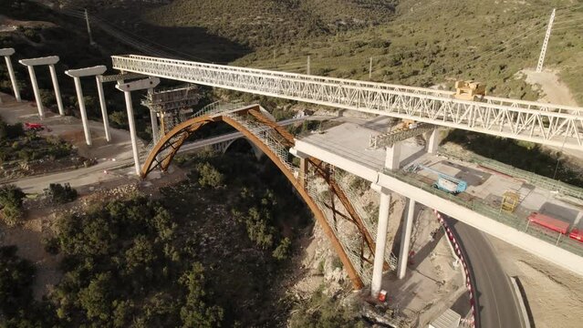 Orbit drone footage from above of an unfinished  bridge&acute;s structure under construction in Barranco de la Bota in Morella on a sunny afternoon